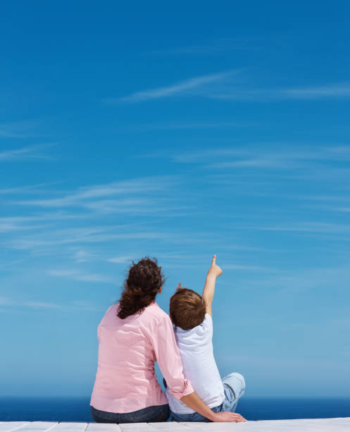 Son with his mother pointing at blue sky