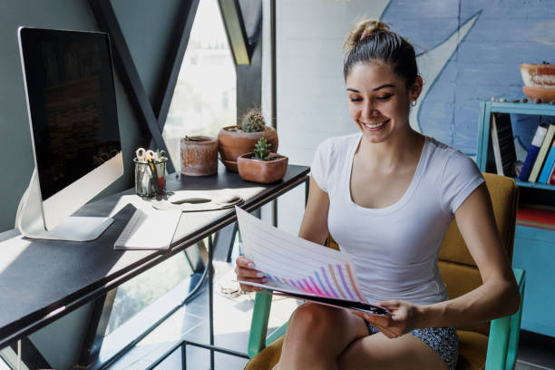 istock latin woman working from Home using Desktop Computer in Creative Apartment. Hispanic female in home office in Mexico latin america 1575246526