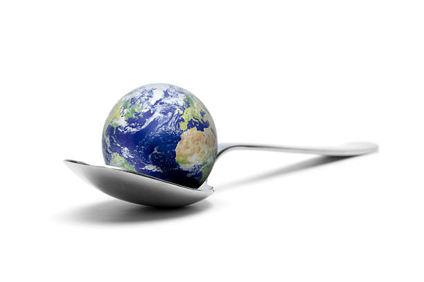 Hand trying to taste a world globe with a fork. Global business ventures appetite related concept.