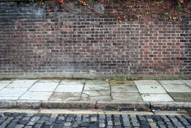 istock Urban background UK - Red brick wall with sidewalk 157525141
