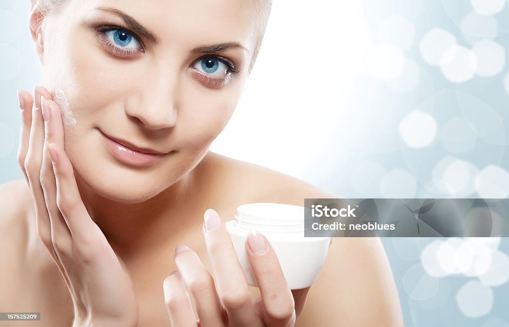 Женщина, применяя Увлажняющий крем крем на лицо. - Стоковые фото Бутылка роялти-фри