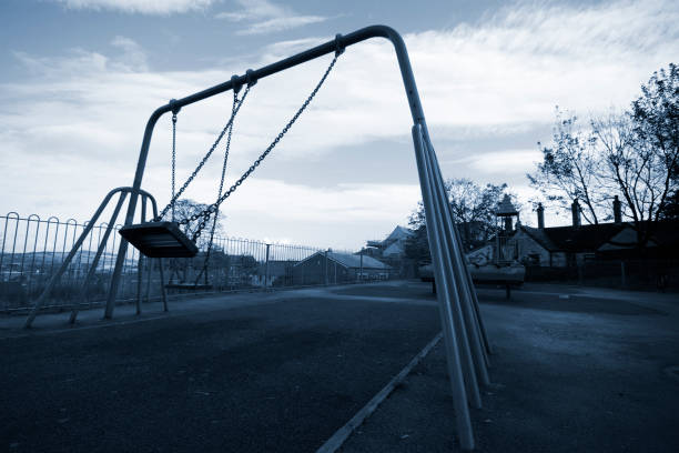 A grayscale playground swing in mid swing stock photo