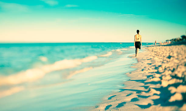 istock Young woman walking in the sunset 157525442