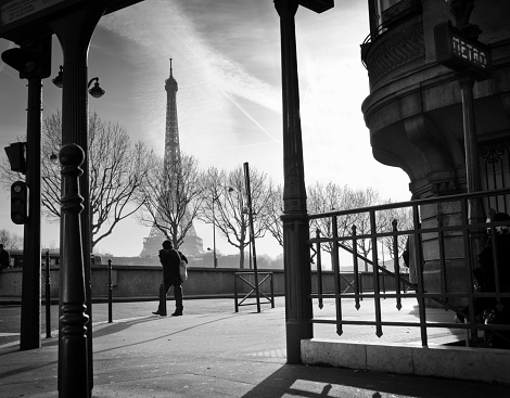 Tourist with umbrellas and raincoats look to the landmark of Paris, the Eiffel Tower under a heavy cloudy sky. 06/05/2022 -1 Av. Gustave V de Suède, 75116 Paris, France
