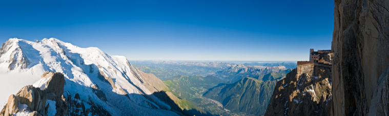 Panoramic vista over the high altitude Alpine landscape of the Mont Blanc Massif and snow capped summit, D
