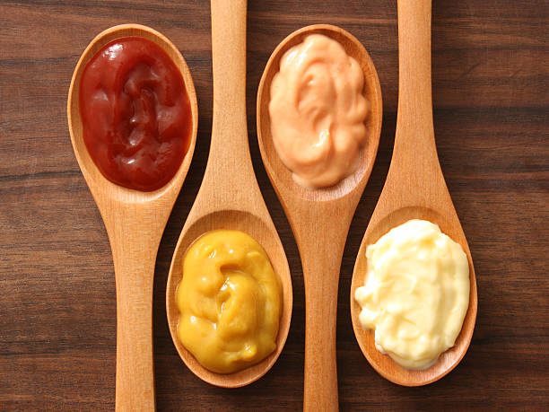 Condiments and spoons Four spoons with varieties of condiments food dressing stock pictures, royalty-free photos & images