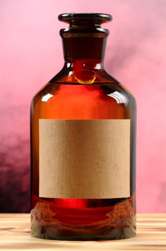 Vintage brown glass bottle is in smoke with an empty label on it, as a design element.