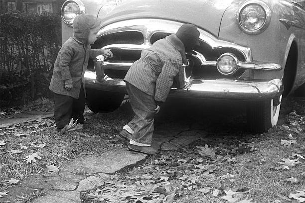 istock boys inspecting Packard Coupe car 1955, retro 157526508