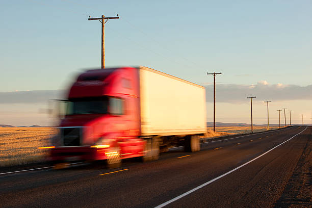 Tractor trailer speeds by at sunset stock photo