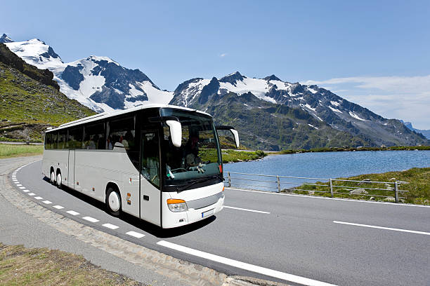 White bus crossing the alpes stock photo