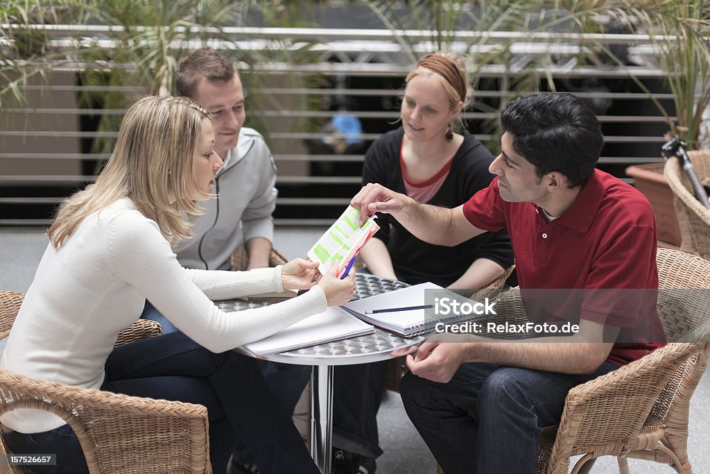 Gruppo di quattro multi etnica studenti nel lavoro di squadra - Foto stock royalty-free di Imparare