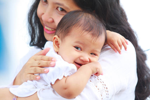 istock happy asian mom holding her baby 157526907