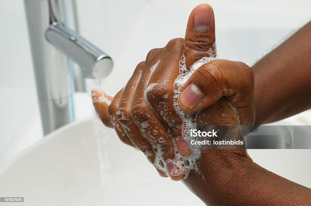 Hand Washing - Rotational Rubbing of Thumb An African American hand washing.  Part of Surgical Scrub Technique for Hand Decontamination Washing Hands Stock Photo