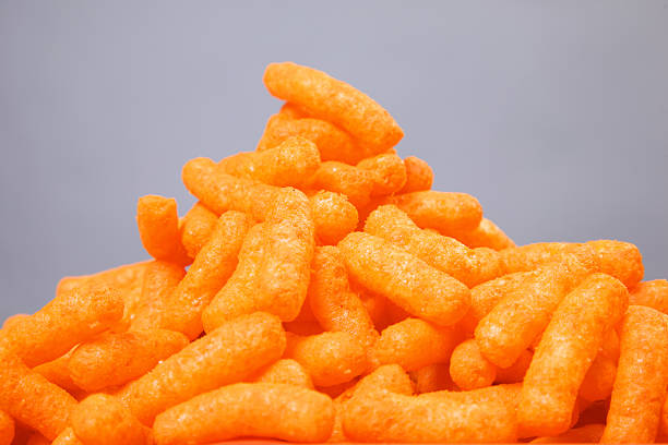 cheese puffs- orange lunch tray diet series stock photo