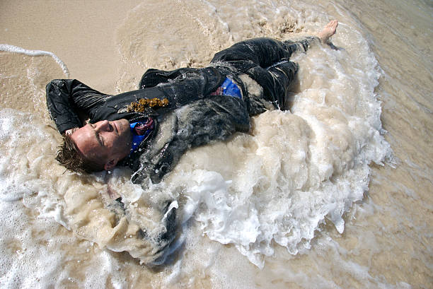 náufrago empresário lavado em sandy onda - stranded beached beach businessman imagens e fotografias de stock