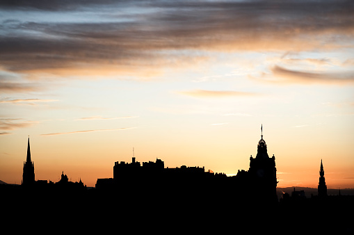 Cityscape of Old Edinburgh at sunset, featuring several famous landmarks, including from left to right: St John’s Church (or Highland Tolbooth Kirk), Camera Obscura, Edinburgh Castle, Balmoral Hotel Clock Tower and The Scott Monument on Princes Street.