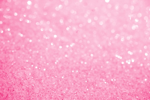 XXXL photo of crystal glittery pink sugar with selective focus along bottom to create blurred sparkles over most of the top 3/4ths for copy space.  Bright and sweet background.