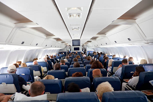 The interior of an airplane with passengers stock photo