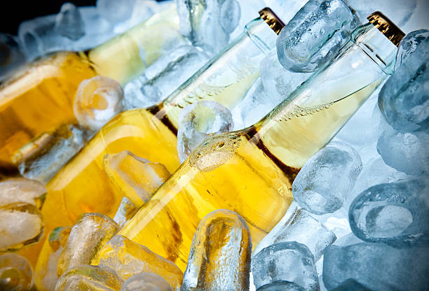 tre bootles di birra sul ghiaccio - beer bottle beer cold alcohol foto e immagini stock