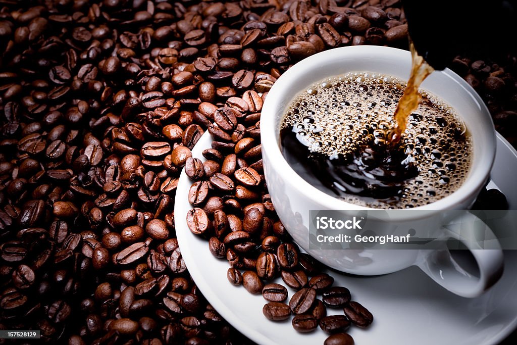 Mug on plate filled with coffee surrounded by coffee beans  Fresh cup of coffee. Coffee - Drink Stock Photo