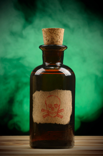 Vintage poison - chemical bottle is an old wooden table with green fog. 