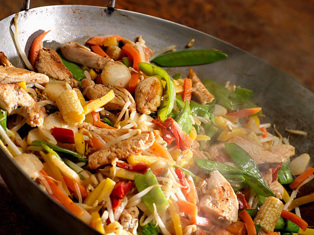 fried chicken stir fry with rice and chinese vegetables with rice and fried egg in white plate on wooden background. Vegetable for good health green. Thai food.