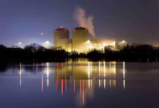 centrale nucléaire de nuit, avec des reflets de l'eau - megawatt photos et images de collection