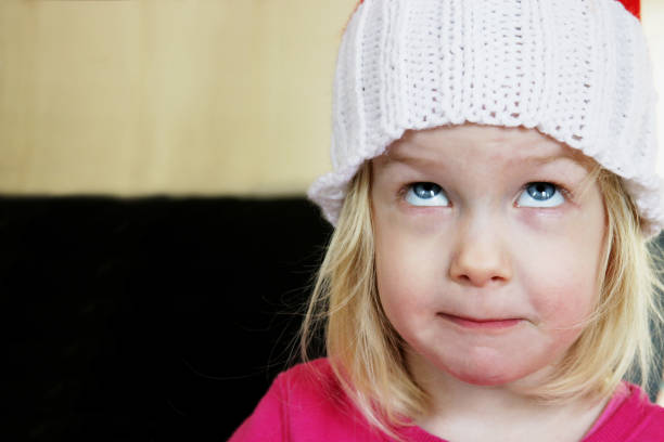 Melancholy pretty young blonde girl in purple hat. Blurry background with copy space