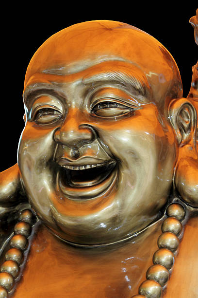 istock Bronze smiling buddha isolated on black 157528903