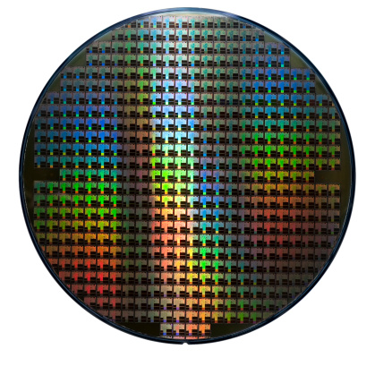 Isolated silicon wafer with hundreds of integrated circuits. Rainbow color patterns.