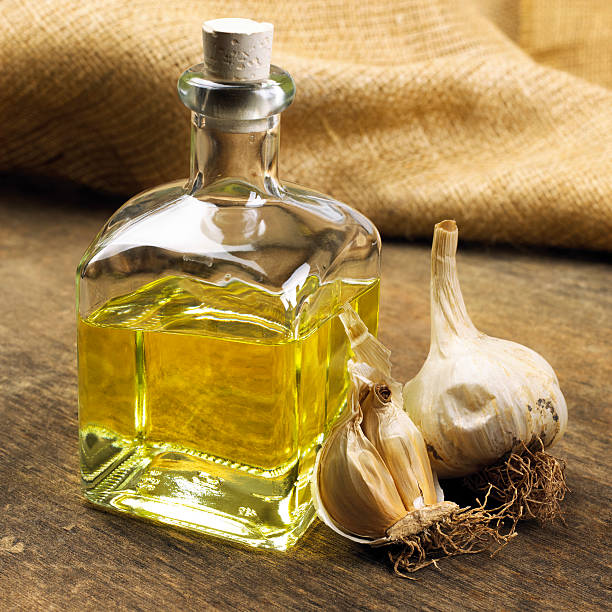 in the foreground a glass cruet with Italian extra virgin olive oil, garlic and dried chilli. still life