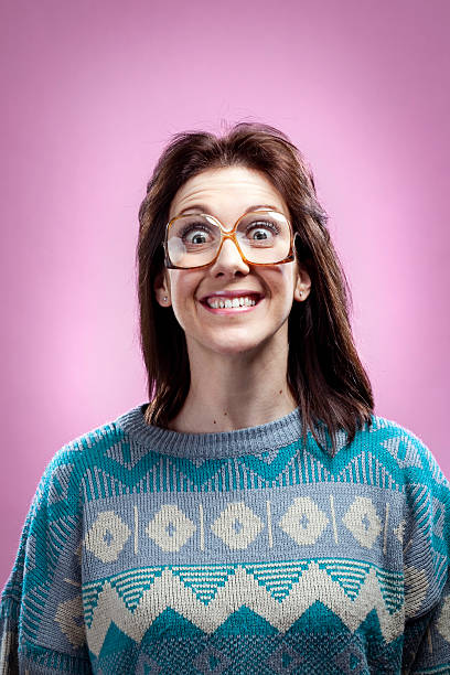 Crazy Pink 1980s Girl and Sweater A portrait of a young adult woman dressed in a late 1980 early 1990 style with a cheesy smile and hair style. cheesy grin stock pictures, royalty-free photos & images
