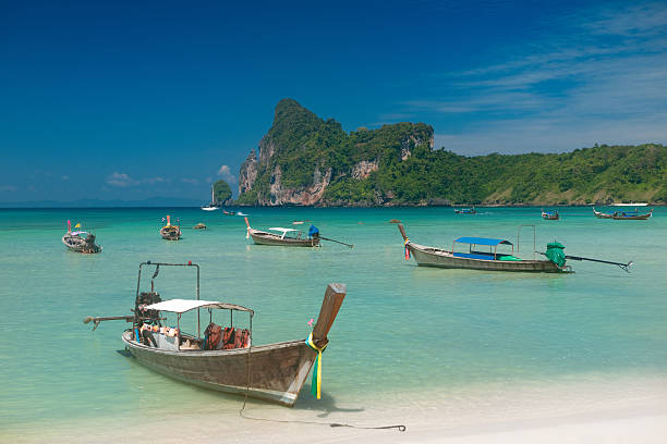 Traditional wooden  boat in a picture perfect tropical bay on Koh Phi Phi Island, Thailand, Asia.