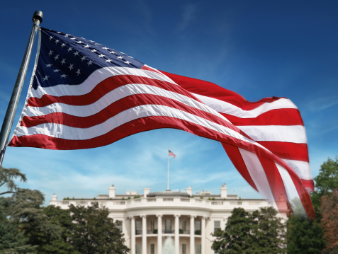 Bandera estadounidense en frente de la casa blanca photo
