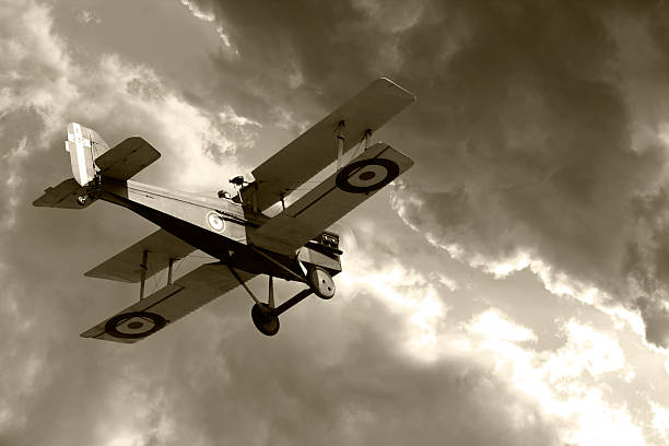 Vintage biplane flying into storm clouds stock photo