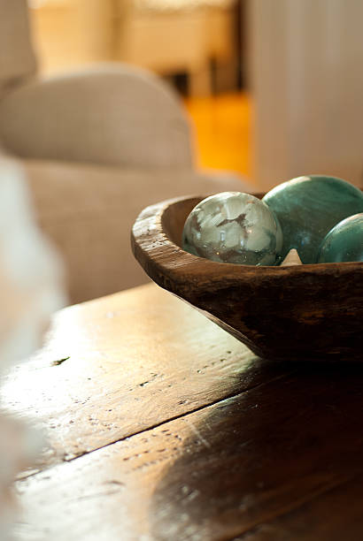 Dark wood coffee table with a bowl of green balls on stock photo