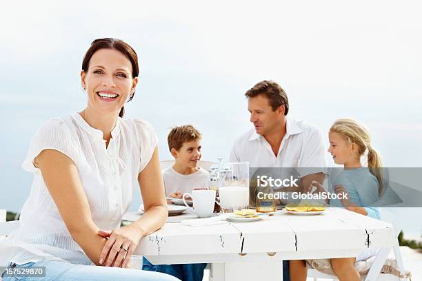 Glückliche Frau Mit Ihrer Familie Hat Frühstück Im Hintergrund Stockfoto und mehr Bilder von 35-39 Jahre