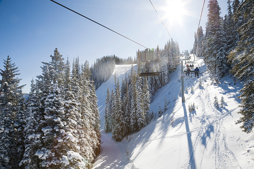 New modern spacious big cabin ski lift gondola against snowcapped forest tree and mountain peaks covered in snow landscape in luxury winter alpine resort. Winter leisure sports, recreation and travel.