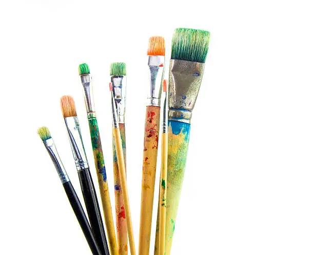 used paintbrushes with paint on them isolated on white
