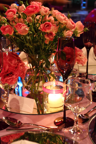 Photo of a dinner table,  with a vase with roses