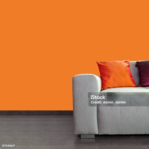 Photo libre de droit de Moderne Gris Canapé Et Coussins Colorés Contre Mur Orange banque d'images et plus d'images libres de droit de Salon - Pièce
