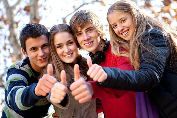 группа подростков друзей, показывая пальцем вверх - thumbs up teenager adolescence group of people стоковые фото и изображения