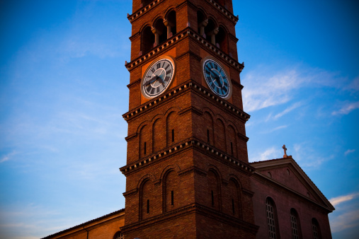 A clock tower of an ornate brick church in Pasadena, CA