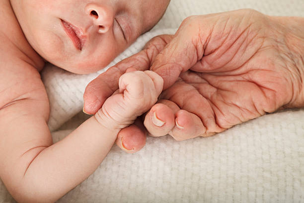 sleeping baby holding great grandmother's hand