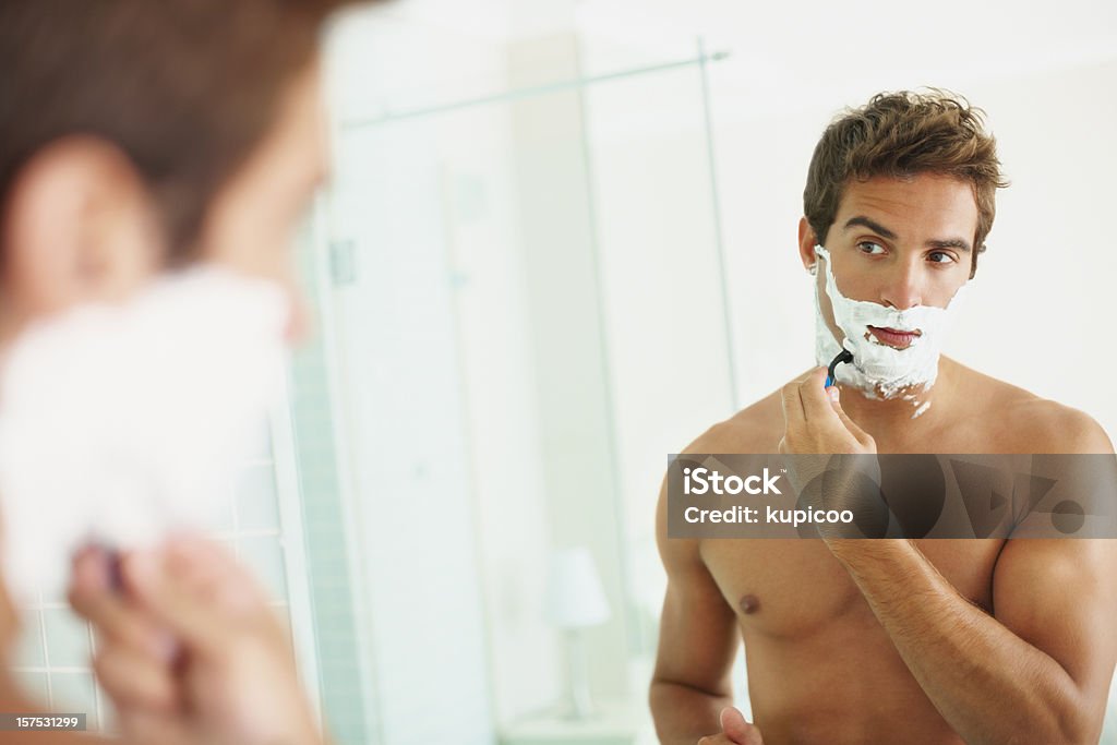 Atractivo joven afeitarse en su barba - Foto de stock de Afeitarse libre de derechos