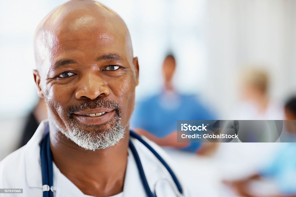 Masculino médico com seus colegas na parte de trás - Foto de stock de 40-44 anos royalty-free