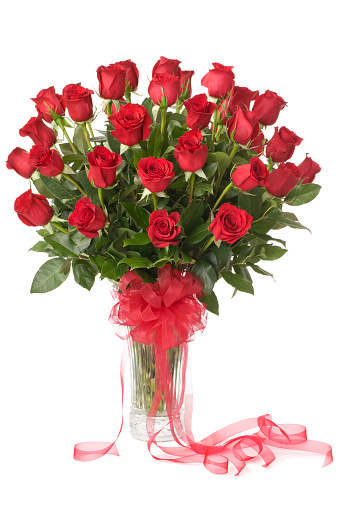A bouquet of red roses with drops of water on a mirror table with a beautiful reflection, decorative hearts.Floral background for Valentine's Day.Festive background for wedding,mother's day,birthday