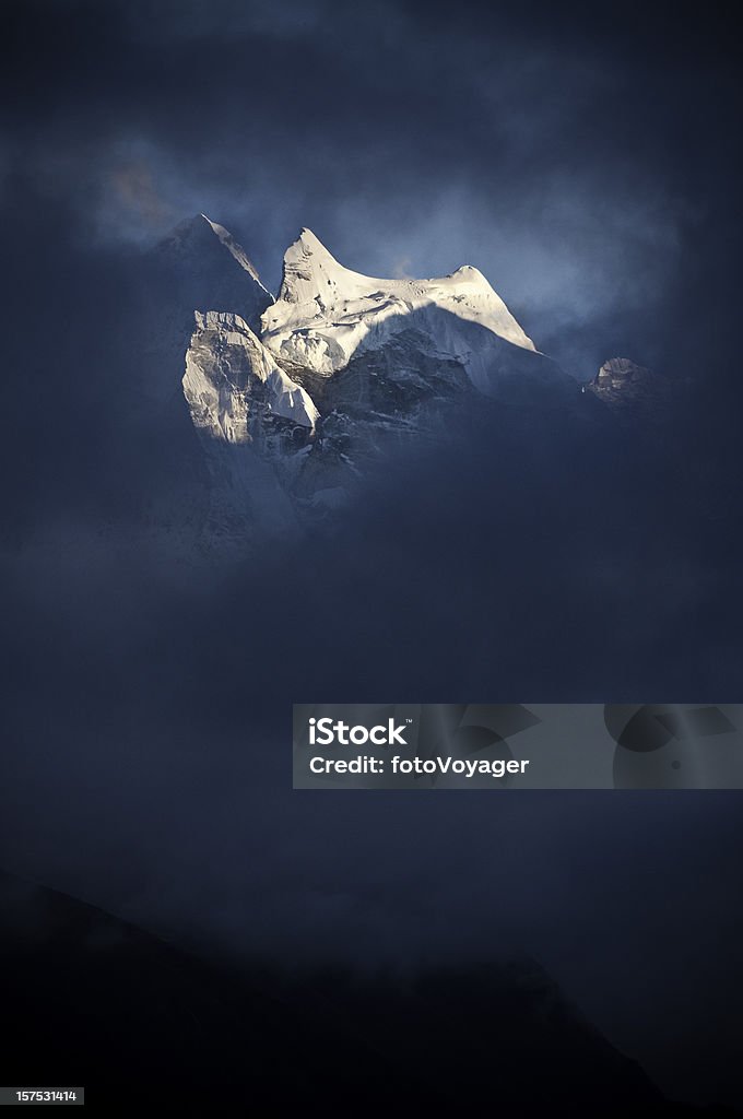 Sunlit snow Himalaya peak dark swirling storm cloud Khumbu Nepal  Asia Stock Photo