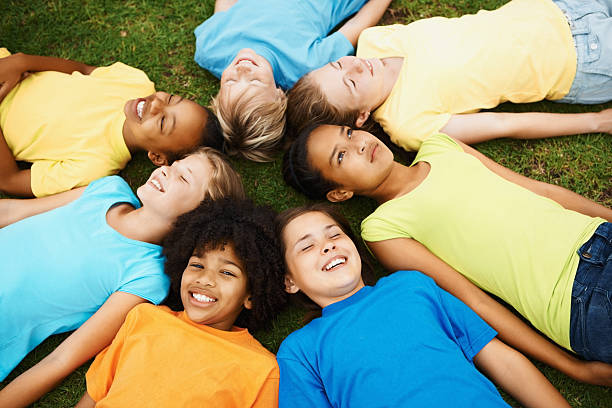 istock High angle view of multi ethnic children lying on grass 157531416