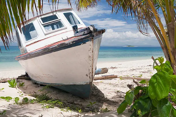 An old, abandoned boat on Bounty Island's beach, Fiji.